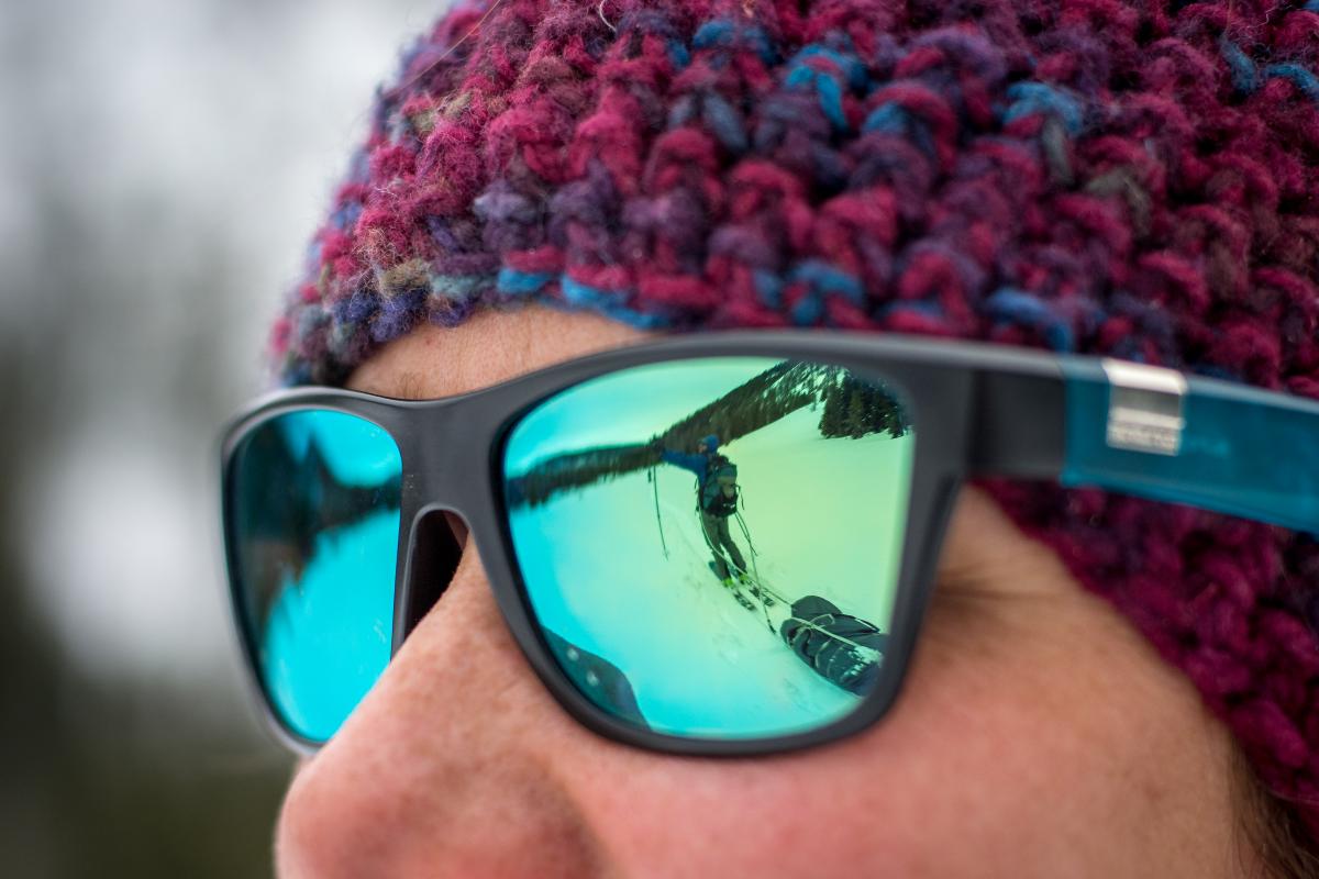 NOLS participant pulling a sled in the snow while backcountry touring is reflected in someone's sunglasses