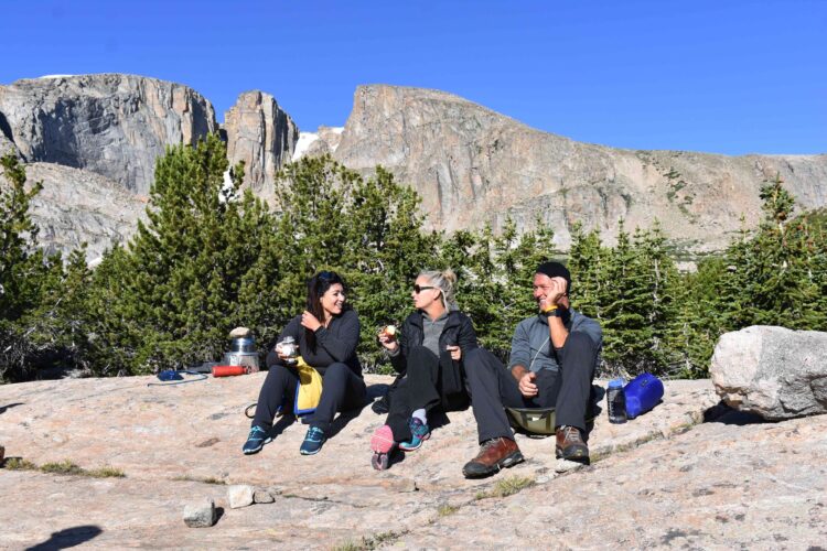 Course participants laugh together while relaxing in camp.