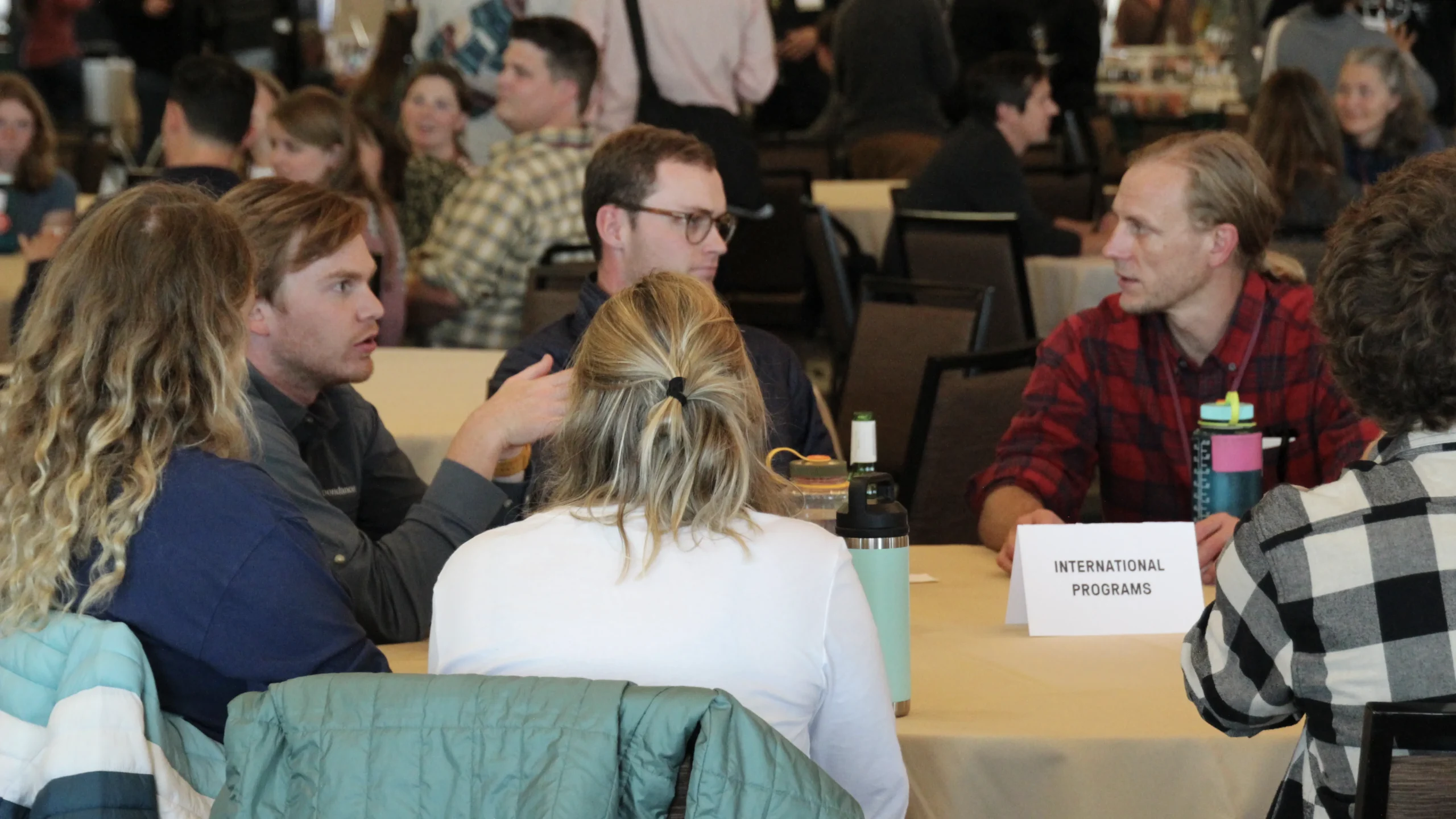 a group of people at a table talk engagingly with one another